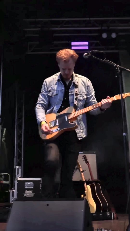 Mikkel Toustrup på scenen med Rocket Brothers-banneret bagved